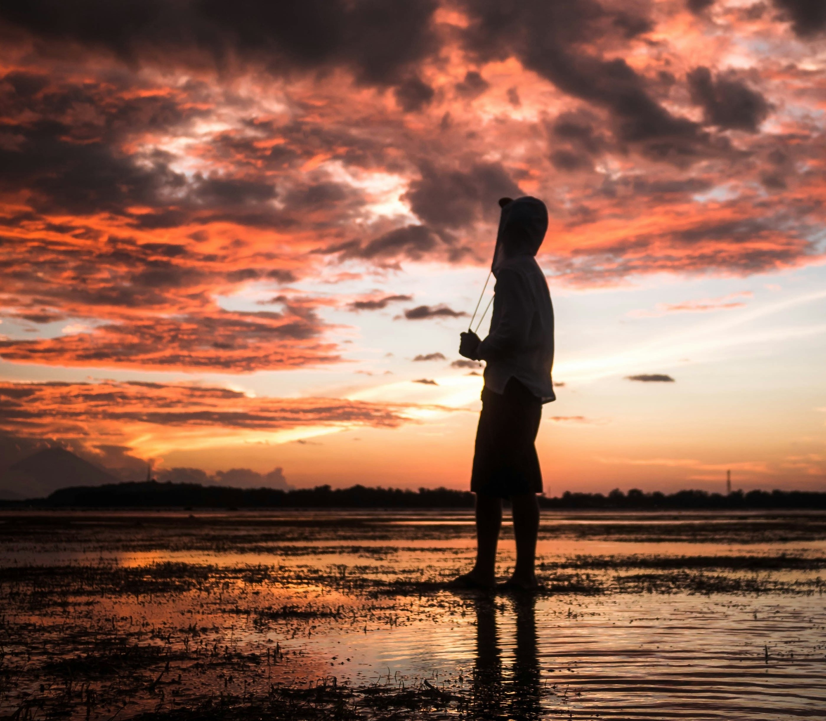 A person looking up  at the beach with a perfect sunrise